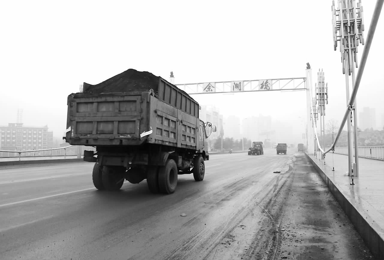 一辆敞篷的运煤车经过佘湖桥,大桥两边积累了很厚的淤泥